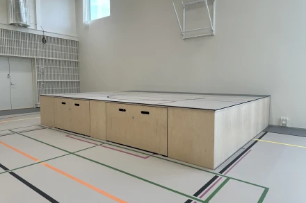 Lattiasta nouseva näyttämö monitoimitilassa