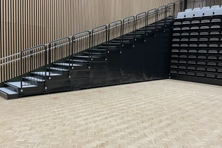 Mittatilaustyönä valmistettu suojaverho katsomoportaikon eteen